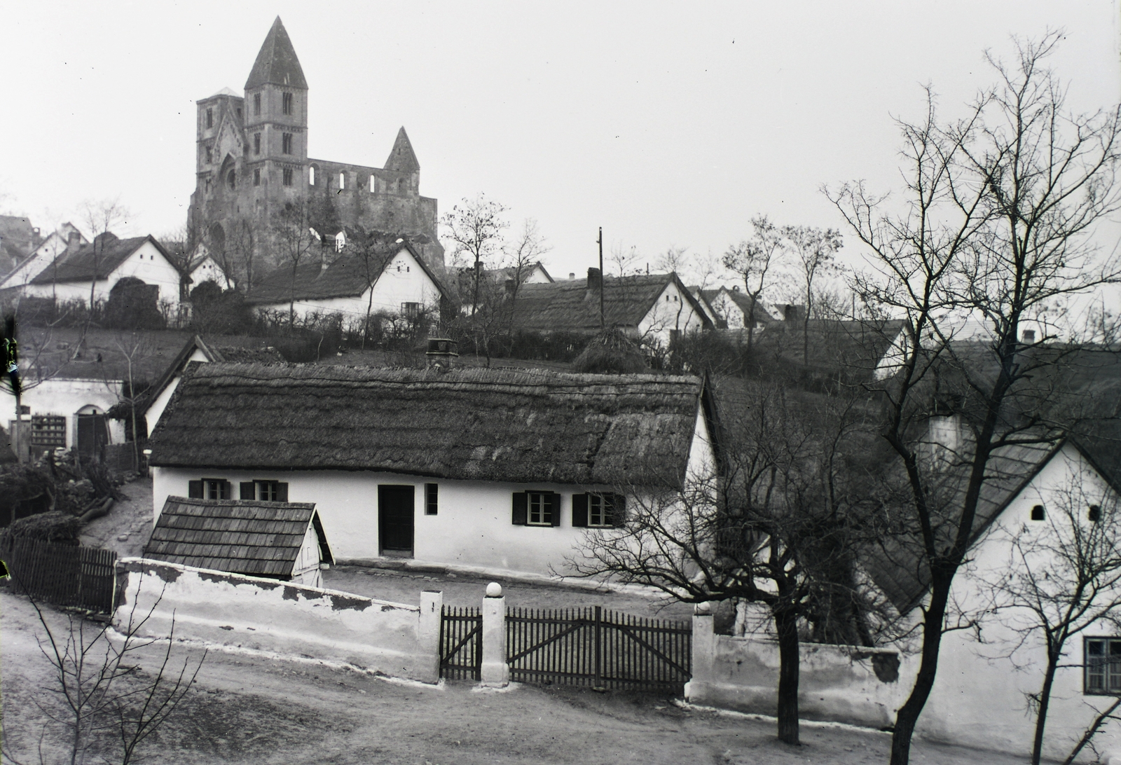 Hungary, Zsámbék, Táncsics Mihály utca, a háztetők felett a premontrei templom romjai., 1929, Schermann Ákos, Schermann Szilárd, church, street view, picture, ruins, damaged building, Catholic Church, tower, Premonstratensians, Fortepan #95395