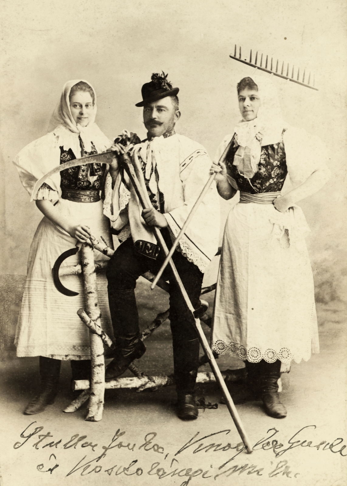 Slovakia, Zlaté Moravce, élőkép parasztviseletben. A felvétel 1890 körül készült., 1900, Buzinkay Géza, hat, studio, folk costume, harvest, headscarf, rake, scythe, sickle, attire, three people, boots, Fortepan #96139