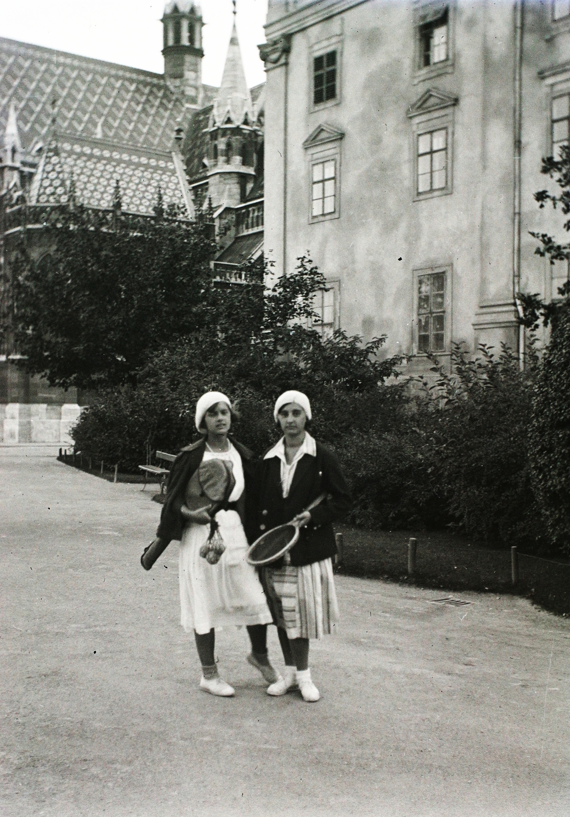 Magyarország, budai Vár, Budapest I., balra a Mátyás-templom, jobbra az egykori jezsuita kollégium, ma a Hilton szálló van a helyén., 1931, Buzinkay Géza, kalap, utcakép, kettős portré, teniszütő, teniszlabda, Budapest, Fortepan #96185