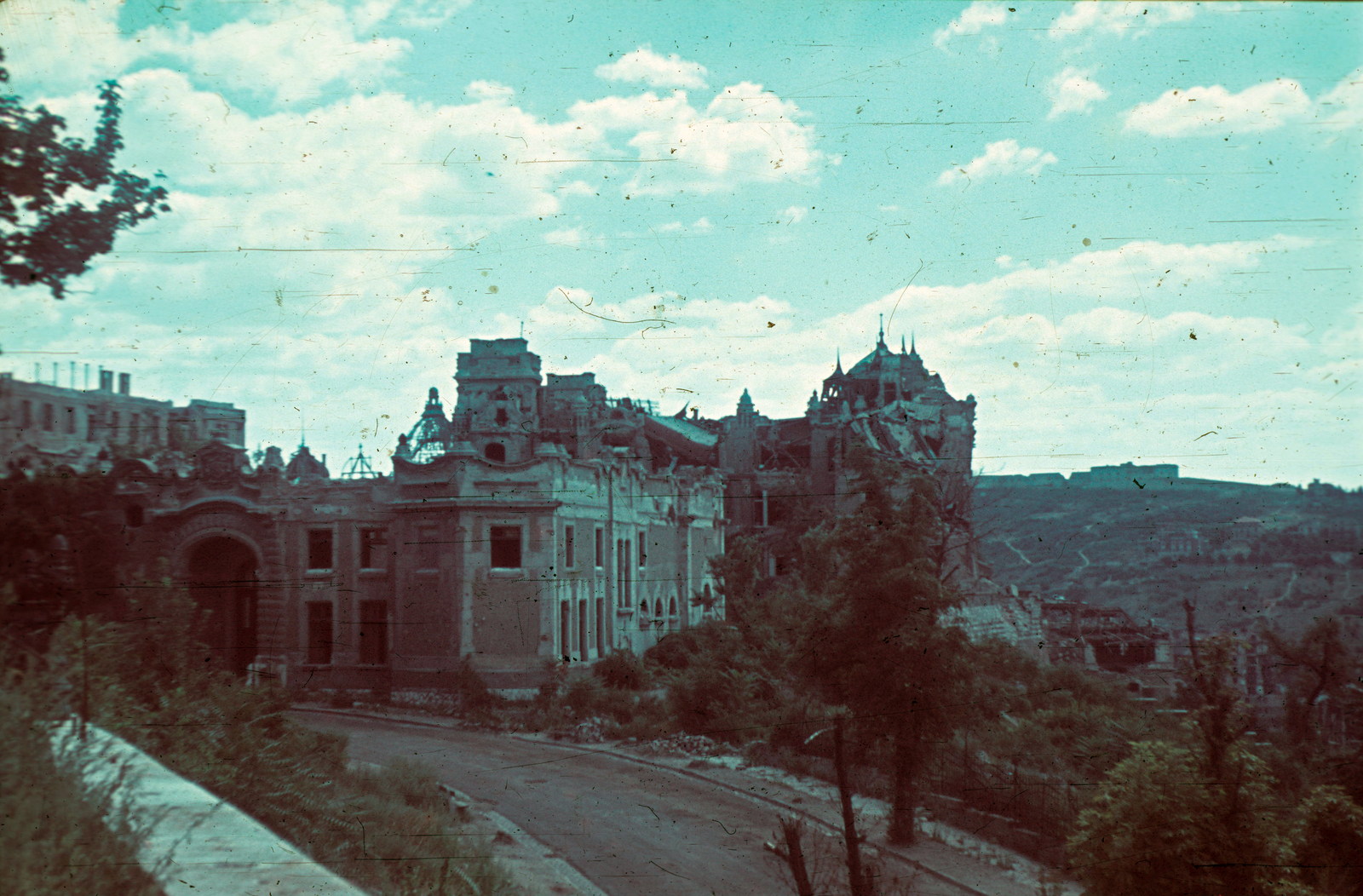 Magyarország, budai Vár, Budapest I., a Palota út felső szakasza a Tóth Árpád sétányról (Gróf Bethlen István bástyasétány) nézve. Szemben hátul a József főhercegi palota, előtte a hozzátartozó istálló., 1947, Schermann Ákos, Trompler Elek, színes, háborús kár, épületkár, Budapest, Fortepan #96594