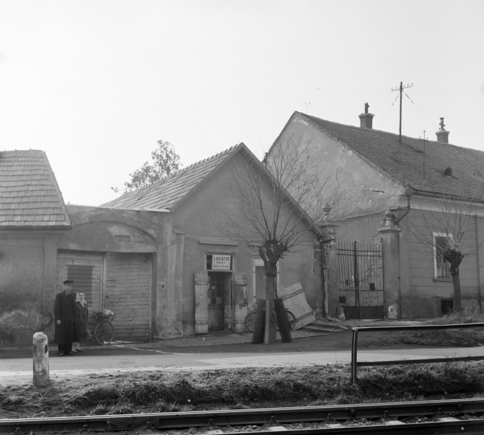 Hungary, 1966, UVATERV, bicycle, railway, sign-board, railing, street view, workshop, man and woman, commuter train, rails, gas tank, chain-link fence, Fortepan #97176