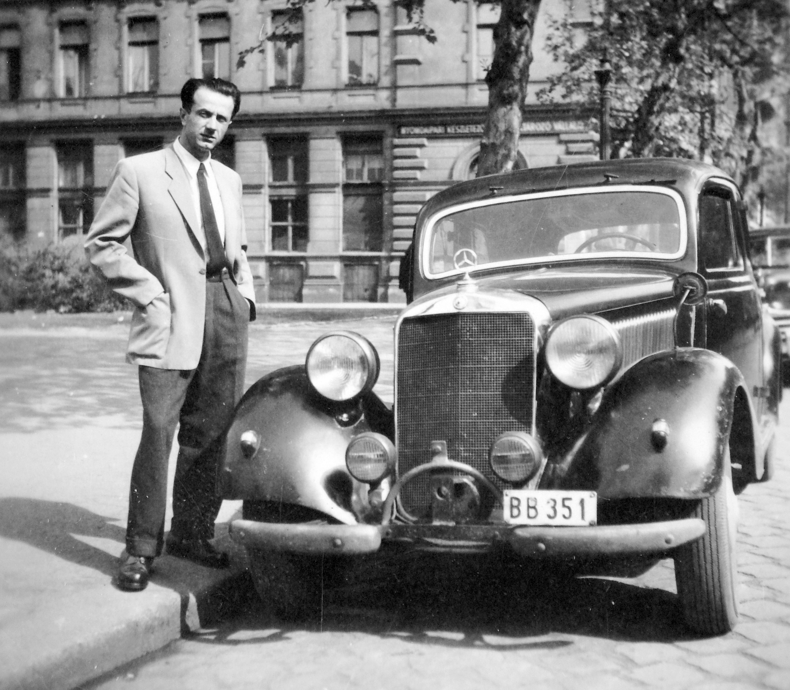 Hungary, Budapest V., balra az ekkor névtelen, ma Podmaniczky Frigyes tér, háttérben a Bajcsy-Zsilinszky út - Bank utca sarok. Mercedes 170 típusú személygépkocsi., 1950, Fortepan, German brand, genre painting, Mercedes-brand, automobile, Mercedes-Benz 170V, number plate, Budapest, hands in pockets, Fortepan #9770