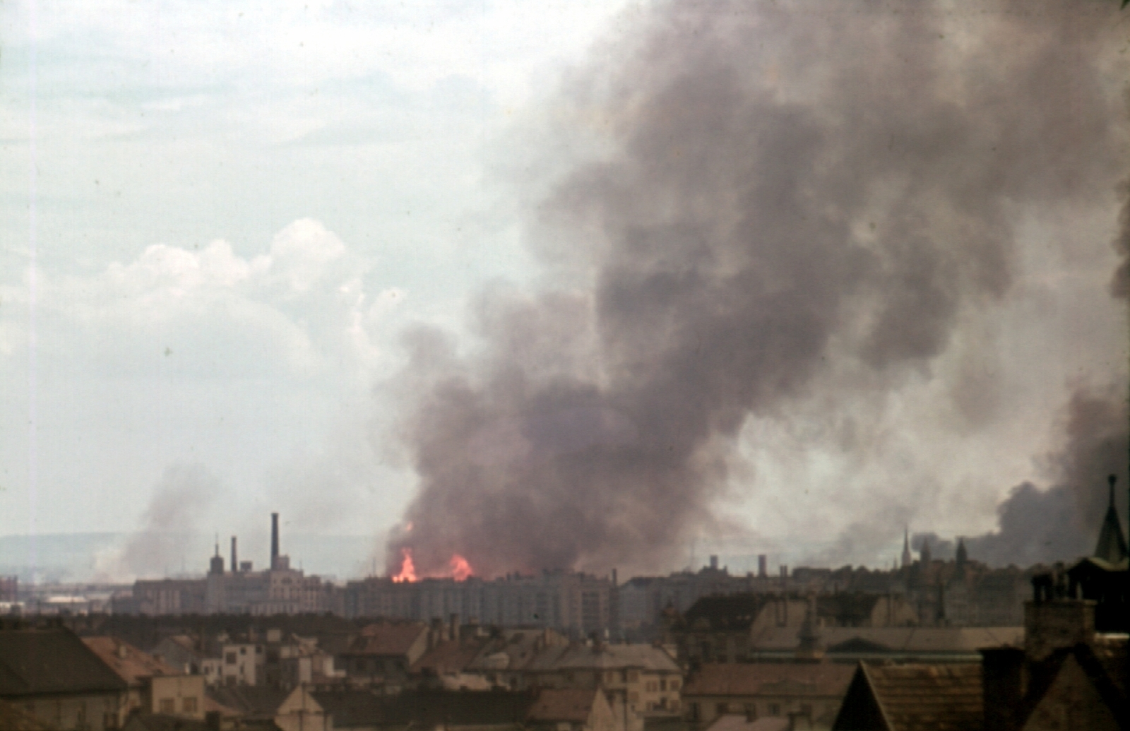 Magyarország, Budapest I.,Budapest XIII., vízivárosi háztetők, kilátás a Fiáth János utca irányából Újlipótváros felé, háttérben a lángoló Angyalföld az ipartelep szőnyegbombázása után., 1944, Fortepan, színes, háborús kár, bombázás, második világháború, látkép, füst, tűz, Budapest, Fortepan #9805