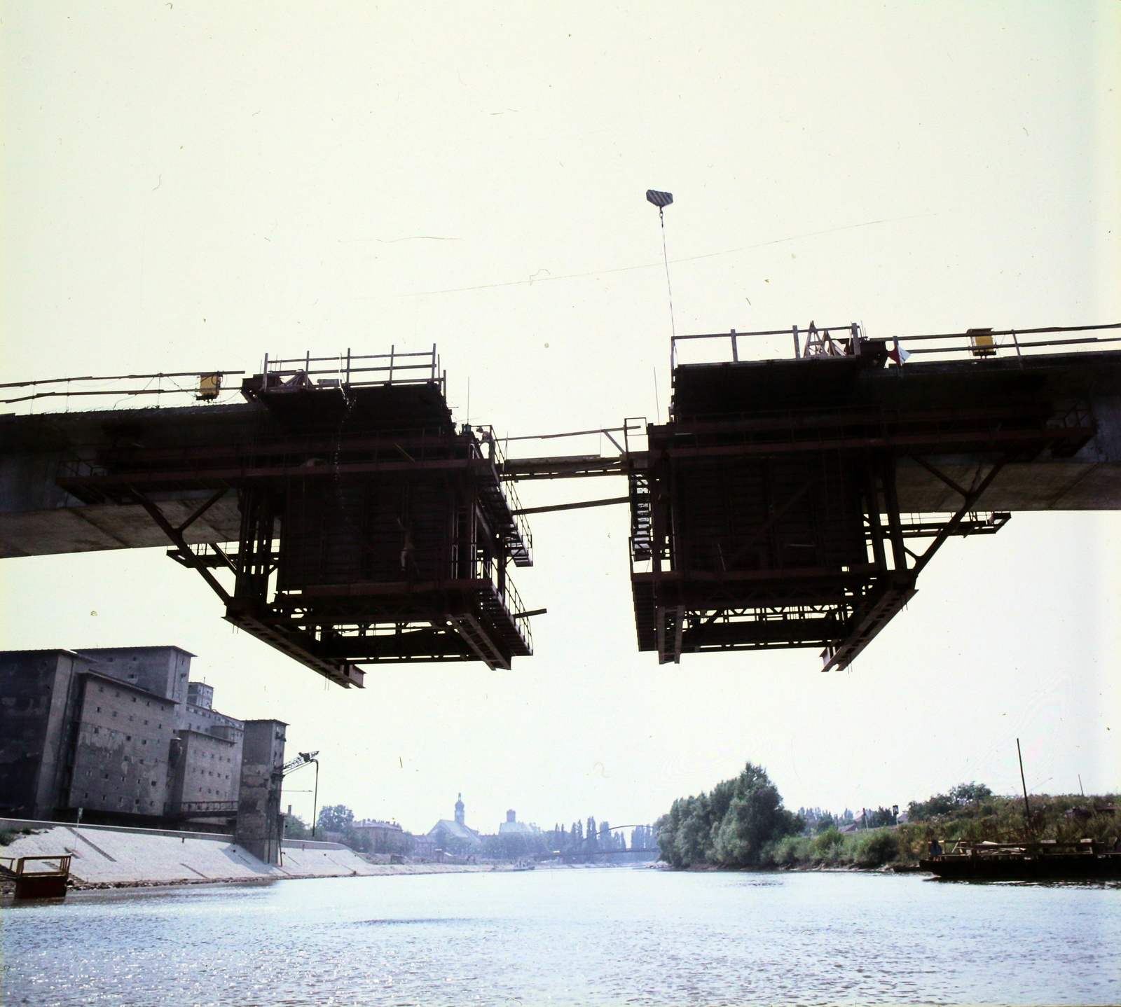 Hungary, Győr, Mosoni-Duna, a Széchenyi híd építése. Balra az elevátor, háttérben a Kossuth (Révfalui) híd., 1978, UVATERV, colorful, bridge building, warehouse, grain elevator, Fortepan #99219