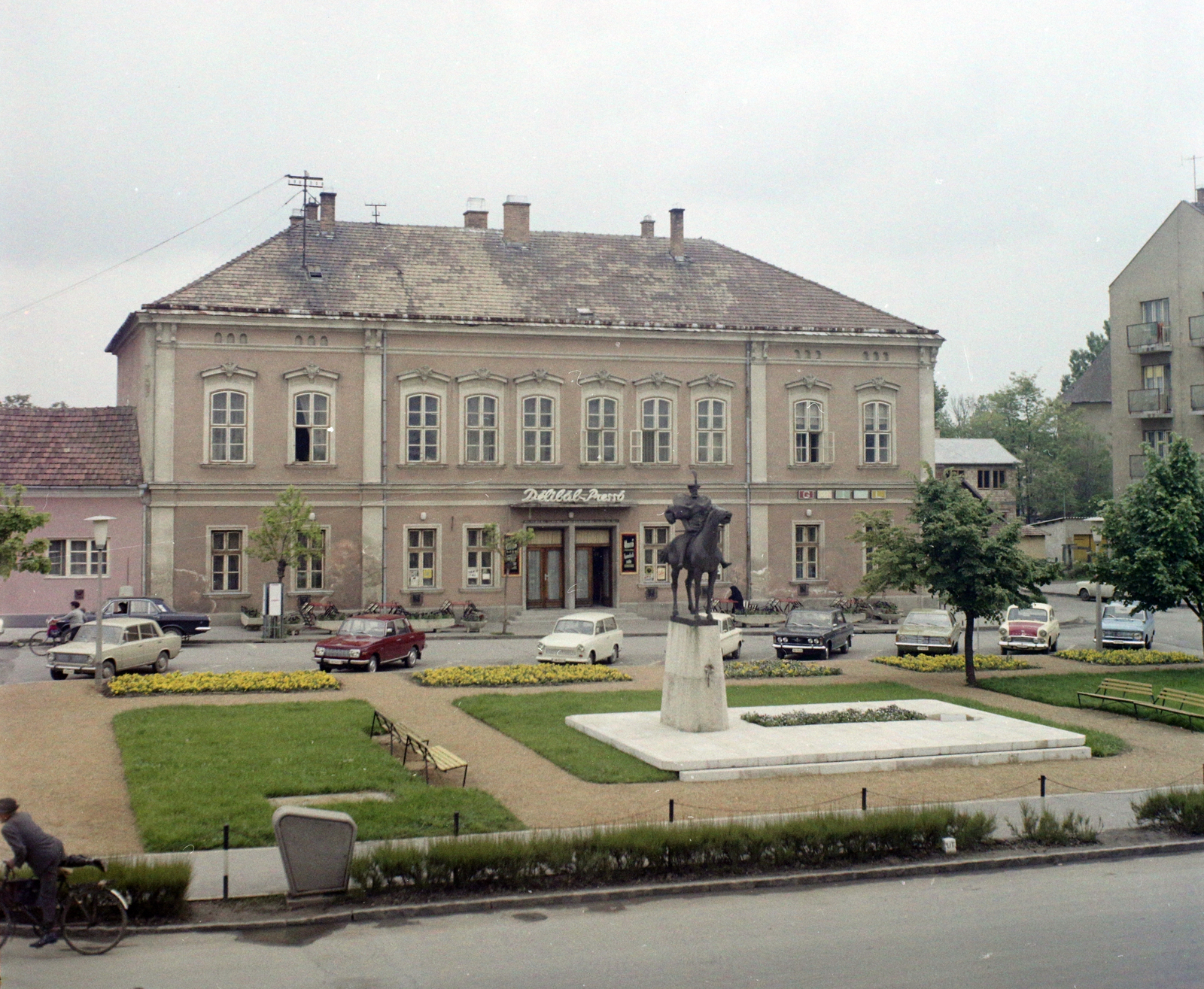 Hungary, Hajdúszoboszló, Hősök tere, Bocskai István lovasszobra (Marton László, 1972.). Háttérben a Bástya (egykor Bika) szálló, ma Nelson Hotel épülete., 1974, UVATERV, colorful, label, square, hotel, espresso, car park, horse sculpture, neon sign, István Bocskai-portrayal, Fortepan #99336