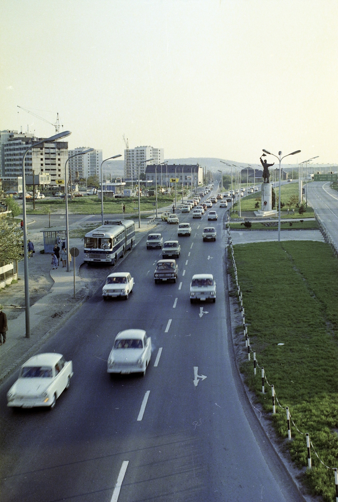 Hungary, Budapest XI., Budaörsi út, szemben az Osztapenko szobor a Balatoni út és az M1-M7 közös szakaszának találkozásánál. Balra az épülő Őrmezői lakótelep., 1976, UVATERV, colorful, traffic, sculpture, highway, Ostapenko Ilya portrayal, Budapest, Fortepan #99372