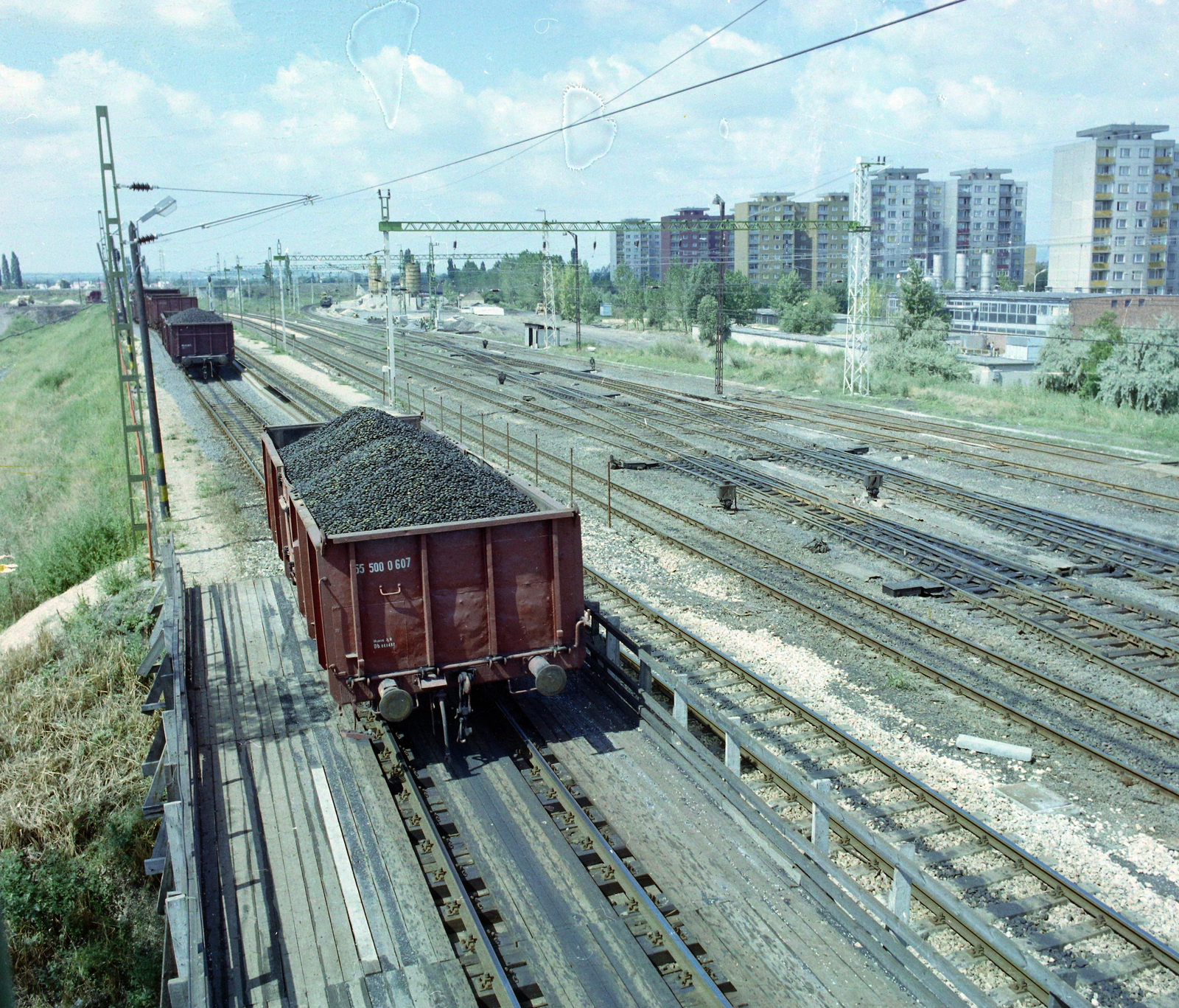 Hungary, Székesfehérvár, vasútállomás, háttérben a Tóvárosi (Münnich Ferenc) lakónegyed házai., 1987, UVATERV, railway, colorful, coach, Fortepan #99506