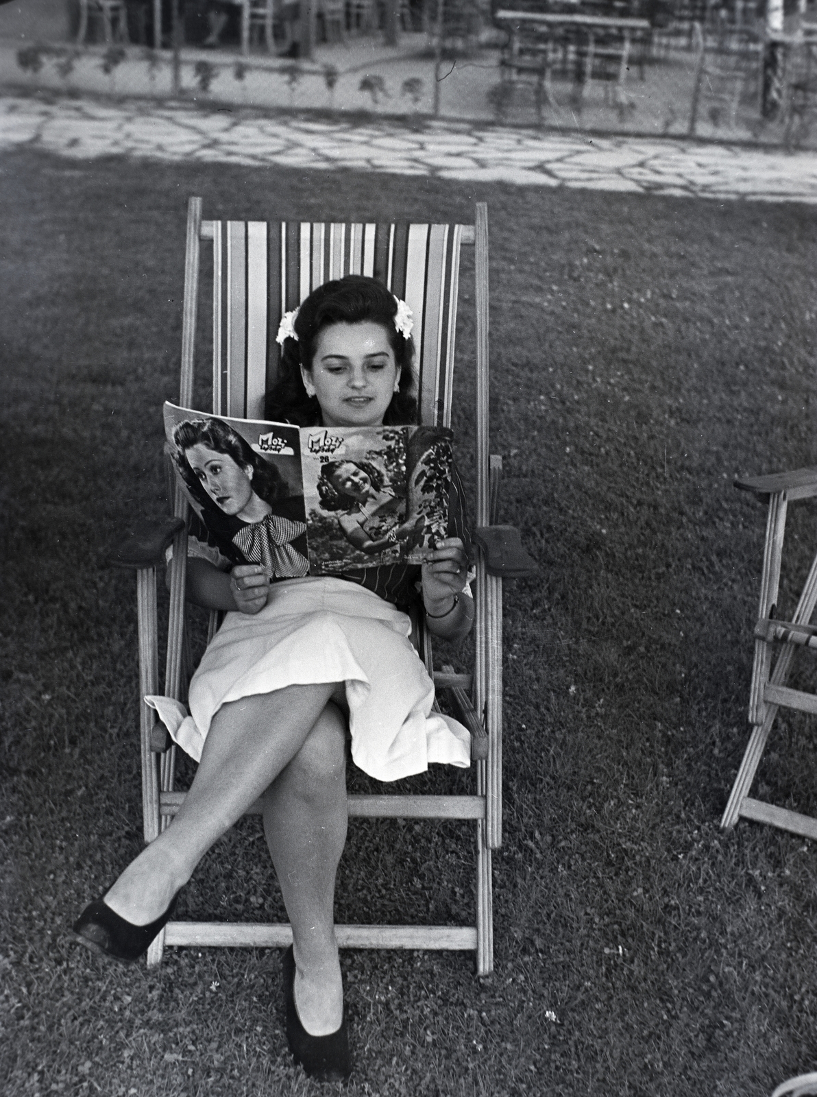 Hungary, a hölgy kezében lévő Mozi újság címlapján Szeleczky Zita színésznő., 1943, Kurutz Márton, celebrity, reading, newspaper, deck chair, skirt, hair clip, Fortepan #9985