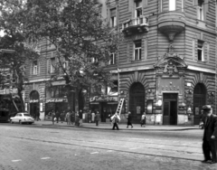 Magyarország, Budapest VIII., Rákóczi út 11., Puskin utca sarok. A kép forrását kérjük így adja meg: Fortepan / Budapest Főváros Levéltára. Levéltári jelzet: HU_BFL_XV_19_c_11, 1958, Budapest Főváros Levéltára / Városrendezési és Építészeti Osztályának fényképei, A Fővárosi Tanács VB Városrendezési és Építészeti Osztályának, Budapest, épületdísz, divatáru, kváderkő, létra, postahivatal, szabóság, Fortepan #103342