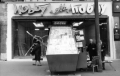 Magyarország, Budapest VI., Deák Ferenc tér, hírlapárus pavilon a Hobby bolt előtt. A kép forrását kérjük így adja meg: Fortepan / Budapest Főváros Levéltára. Levéltári jelzet: HU_BFL_XV_19_c_11, 1968, Budapest Főváros Levéltára / Városrendezési és Építészeti Osztályának fényképei, A Fővárosi Tanács VB Városrendezési és Építészeti Osztályának, újságárus, Budapest, Fortepan #103608