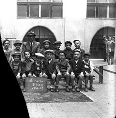 Magyarország, Budapest VII., a Kazinczy utcai orthodox központ udvara a zsinagógánál. Csoportkép egy elsős fiúosztályról., 1947, Hámori Gyula, kalap, iskola, nyakkendő, osztálykép, kantárosnadrág, svájcisapka, fiú, pad, micisapka, gyerek, zsidóság, iskolaudvar, Budapest, Fortepan #104733