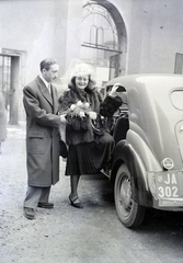 Hungary, Budapest VII., Dohány utcai zsinagóga udvara, háttérben a Wesselényi utcai kapu., 1948, Hámori Gyula, taxicab, crest, fur coat, bouquet, untitled, number plate, Kossuth coat of arms, Budapest, entering the car, automobile, Fortepan #104773