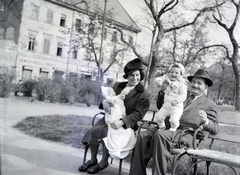 Magyarország, Budapest V., Erzsébet (Sztálin) tér a Deák Ferenc tér felé nézve, háttérben balra a Kemnitzer ("Két török") ház., 1946, Hámori Gyula, Budapest, vidámság, pad, csecsemő, gyerek, nagyszülő, kézben tartani, Fortepan #105040