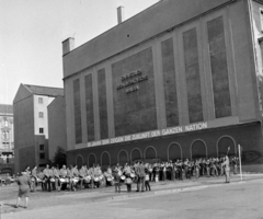 Németország, Berlin, Kelet-Berlin, Jägerstrasse, a zenekar a 61. számú üres telken játszik, mögöttük jobbra az 59-60. számú ház tűzfala., 1969, Hunyady József, zenekar, NDK, propaganda, német szöveg, Fortepan #106532