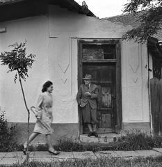 Hungary, Mezőtúr, a kapuban Csabai Wágner József festő., 1965, Hunyady József, hat, tie, cigarette, smoking, pavement, pedestrian, glasses, umbrella, door, woman, breech, gaping, pantyhose, sapling, Best of, standing in door, Fortepan #107170