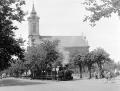 Hungary, Békéscsaba, Kossuth tér, evangélikus Nagytemplom., 1955, Gyöngyi, steam locomotive, railway, church, rail, narrow-gauge railway, church clock, Empire style, Lutheranism, bicycle, Fortepan #10936