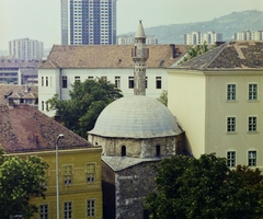 Magyarország, Pécs, Jakováli Hasszán dzsámija és a minaret a Hotel Pannónia ablakából nézve. Távolban az épülő 25 emeletes panelház a "pécsi magasház"., 1976, Bauer Sándor, színes, minaret, mecset, magasház, Fortepan #110799