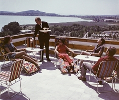 Magyarország, Balatonfüred, Hotel Marina, terasz. Háttérben a kemping, a hajógyár és a Tihanyi félsziget., 1969, Bauer Sándor, színes, terasz, kempingbútor, felszolgáló, Fortepan #111572