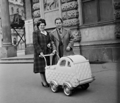 Magyarország, Budapest VIII., Blaha Lujza tér, háttérben a Nemzeti Színház és a homlokzatán lévő emléktábla, a dombormű Moiret Ödön alkotása (1937)., 1957, Bauer Sándor, babakocsi, férfi, nő, Budapest, Fortepan #111662