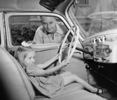 Hungary, Budapest XI., Ladányi Ferenc színművész. A felvétel a Budaörsi úton készült, háttérben a 15. számú ház., 1962, Bauer Sándor, girl, Budapest, steering wheel, vehicle interior, Fortepan #113062