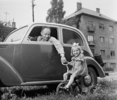 Hungary, Budapest XI., Ladányi Ferenc színművész. A felvétel a Budaörsi úton készült, háttérben a 15. számú ház., 1962, Bauer Sándor, chauffeur, girl, automobile, Budapest, kids' tricycles, Fortepan #113064