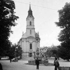 Magyarország, Szekszárd, Béla király tér, Belvárosi templom., 1959, Gyöngyi, templom, automobil, toronyóra, szentháromság szobor, kerékpár, Fortepan #11385