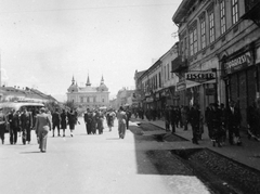 Románia,Erdély, Máramarossziget, Fő tér (ekkor Horthy Miklós tér, ma Piata Libertătii), szemben a Vigadó., 1941, Gyöngyi, autóbusz, utcakép, üzletportál, árok, Fischer, Párizsi magazin, Fortepan #11413