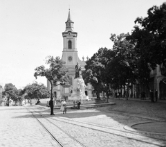 Magyarország, Sátoraljaújhely, Kossuth tér, Kossuth szobor. Háttérben a Szent István király-templom, előtérben a Hegyközi Kisvasút vágányai., 1940, Gyöngyi, vasút, templom, kút, kisvasút, kitérő, fordítókorong, Fortepan #11450