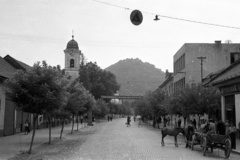 Ukrajna,Kárpátalja, Huszt, Karpatszkoji Szicsi utca (Rákóczi út) a főtér felől nézve, balra a Szent Anna-templom, háttérben a vár., 1958, Répay András, Szovjetunió, templom, ló, szekér, hegy, csikó, cirill írás, Fortepan #115537