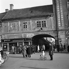 Magyarország, Pápa, Fő tér, az árkádon túl a Kossuth utca., 1967, Gyöngyi, cégtábla, babakocsi, utcakép, üzletportál, orkánkabát, hangszóró, kerékpár, kisiparos, Fortepan #11590