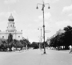 Hungary, Kecskemét, Szabadság tér - Rákóczi út torkolata, balra az egykori zsinagóga, jobbra a fák mögött a Cifra palota., 1955, Gyöngyi, candelabra, road signs, synagogue, lamp post, judaism, public lighting, Moorish architecture, János Zitterbarth-design, Fortepan #11603