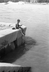 Hungary, Budapest V.,Budapest I., pesti alsó rakpart a Vigadó tér közelében, a túlparton a Döbrentei tér és a Várkert (Beloiannisz) rakpart., 1957, FSZEK Budapest Gyűjtemény / Sándor György, Sándor György, fishing, boy, Budapest, Danube's shore, fishing rod, Fortepan #116978