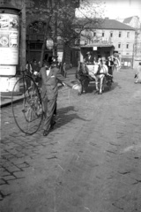 Magyarország, Budapest VIII., Blaha Lujza tér a Népszabadság székháza előtt, háttérben a Corvin Áruház és a Rókus Kórház. A Kandó Kálmán Híradás- és Műszeripari Technikum végzős diákjai által rendezett jelmezes parádé., 1958, FSZEK Budapest Gyűjtemény / Sándor György, Sándor György, kerékpár, lovaskocsi, hirdetőoszlop, cilinder, cirkusz, Budapest, bevásárlóközpont, Reiss Zoltán-terv, velocipéd, Fortepan #117105