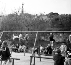 Magyarország, Gellérthegy, Budapest I., játszótér, háttérben a Citadella és a Felszabadulási Emlékmű., 1958, Aradi Péter, Szenczi Mária, Budapest, hintázás, Fortepan #117517