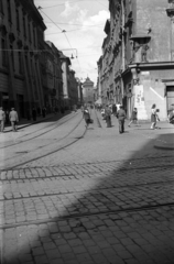 Lengyelország, Krakkó, Plac Mariacki, szemben az ulica Floriańska végén a Flórián kapu., 1947, Bogdan Celichowski, sínpálya, utcakép, épületdísz, járókelő, dombormű, gyalogátkelő, Fortepan #119188