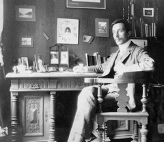 1915, Kurutz Márton, portrait, desk, interior, bookshelf, leg over leg, photo in a frame, Fortepan #11940