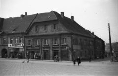 Lengyelország, Rybnik, Rynek, a város főtere, szemben a 15. számú ház, jobbra az ulica Raciborska., 1953, Bogdan Celichowski, utcakép, járókelő, utcaseprő, tér, sarokház, Fortepan #119735