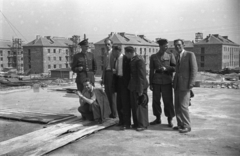 Lengyelország, Krakkó, Nowa Huta városrész, előtérben a mai XVI. számú Líceum építkezése, háttérben az ulica Władysława Orkana házai., 1952, Bogdan Celichowski, férfiak, katona, építkezés, sapkát fogni, Fortepan #119911