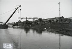 Magyarország, Budapest XIII., Újpesti-öböl, Ganz és Tsa. Villamossági-, Gép-, Waggon- és Hajógyár Rt. Shell tankuszály építése, a part mellett az Újpest (1906) úszódaru, háttérben az Újpesti vasúti híd. Leltári jelzet: MMKM TFGY 2017.1.84., 1937, Magyar Műszaki és Közlekedési Múzeum / Történeti Fényképek Gyűjteménye / Ganz gyűjtemény, uszály, úszódaru, Budapest, portáldaru, Fortepan #122535