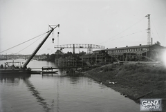 Magyarország, Budapest XIII., Újpesti-öböl, Ganz és Tsa. Villamossági-, Gép-, Waggon- és Hajógyár Rt. Shell tankuszály építése, a part mellett az Újpest (1906) úszódaru, háttérben az Újpesti vasúti híd. Leltári jelzet: MMKM TFGY 2017.1.85., 1937, Magyar Műszaki és Közlekedési Múzeum / Történeti Fényképek Gyűjteménye / Ganz gyűjtemény, uszály, úszódaru, Budapest, portáldaru, Fortepan #122536