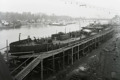 Magyarország, Budapest XIII., Újpesti-öböl, Ganz és Tsa. Villamossági-, Gép-, Waggon- és Hajógyár Rt. A sólyán az épülő DTRT Kassa (1939) Duna-tengerjáró áruszállító hajó. Háttérben az Újpesti vasúti híd. Leltári jelzet: MMKM TFGY 2017.1.395., 1939, Magyar Műszaki és Közlekedési Múzeum / Történeti Fényképek Gyűjteménye / Ganz gyűjtemény, Budapest, Fortepan #122709