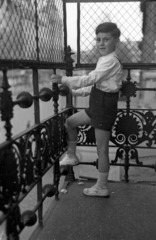 Magyarország, Budapest V., Bajcsy-Zsilinszky út 12. számú ház a József Attila utca sarkán. Távolban a Deák Ferenc tér épületei., 1955, Hámori Gyula, Budapest, kovácsoltvas, erkély, kantárosnadrág, kisfiú, Fortepan #123529