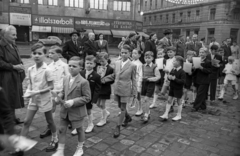 Magyarország, Budapest VIII.,Budapest VII., Rákóczi út, szemben a Nyár utca, elsőáldozók a Szent Rókus-kápolna előtt., 1956, Hámori Gyula, Budapest, rövidnadrág, fiúk, kesztyű, ünneplő ruha, ruhaüzlet, illatszerbolt, villamossági szaküzlet, Fortepan #123650