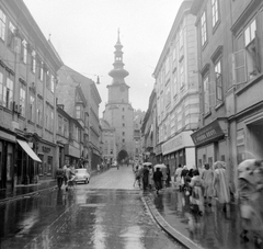 Slovakia, Bratislava, Mihály utca a Mihály-kapu felé nézve., 1958, Gyöngyi, Czechoslovakia, street view, umbrella, Baroque-style, store display, rain, church clock, gate tower, City gate, Fortepan #12755