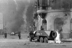 Magyarország, Budapest VII., Rákóczi út - Akácfa utca sarok. Felgyújtott szovjet BTR-152 páncélozott lövészszállító jármű., 1956, Házy Zsolt, páncélautó, forradalom, járókelő, utcakép, járműroncs, füst, tűz, harcjármű, BTR 152, Budapest, Fortepan #12830