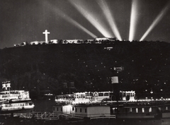 Magyarország, Budapest V.,Budapest I., Vigadó téri hajóállomás, szemben a kivilágított Citadella az Eucharisztikus Világkongresszus idején., 1938, Új Ember hetilap, gőzhajó, díszkivilágítás, Budapest, geometria, kereszt_jelkép, fényszóró, Fortepan #131875