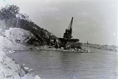 Hungary, Balatonfűzfő,Balatonkenese, a települések között 1914. május 11-én bekövetkezett földcsuszamlással a Balatonba sodort MÁV 220 sorozatú gőzmozdonyának és kocsijainak kiemelése. Balra a régi, csuszamlással sújtott nyomvonalon már személyvonat közlekedik, jobbra épül az új nyomvonal. Leltári jelzet: MMKM TFGY 2017.6.89, 1914, Magyar Műszaki és Közlekedési Múzeum / Történeti Fényképek Gyűjteménye, wreck, crane, Fortepan #132254