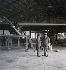 Magyarország, Mátyásföldi repülőtér, Budapest XVI., a Magyar Légiforgalmi Rt. Fokker F-VII típusú repülőgépe előtt Szentkeresztesy (Reisner) Henrik vezérkari ezredes, magyar királyi légügyi igazgató és Wassel Károly vezérkari ezredes a Légügyi Hivatal vezetője. Jobbra a háttérben egy motorok nélküli Caproni Ca.101/bi típusú repülőgép. Leltári jelzet: 2842, 1931, Magyar Műszaki és Közlekedési Múzeum / Archívum / Negatívtár / özv Szintai Józsefné gyűjteménye, repülőgép, hangár, Fokker-márka, Caproni-márka, holland gyártmány, Fokker F.VII, Caproni Ca.101, Budapest, Fortepan #132736