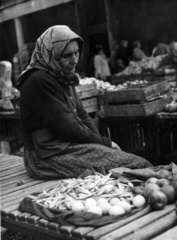 Hungary, Budapest II., Fény utcai piac., 1959, Tőry Klára, market, woman, headscarf, old person, Budapest, sitting on a table, Fortepan #133414