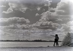 Hungary, Budapest XXII., Duna-part, a túlparton középen a 314 méter magas lakihegyi antennatorony, mellette a 20 kW-os Telefunken adó tornyai és antennája., 1937, Révay Péter, radio broadcasting, Budapest, point a finger, looking into the distance, Fortepan #136295